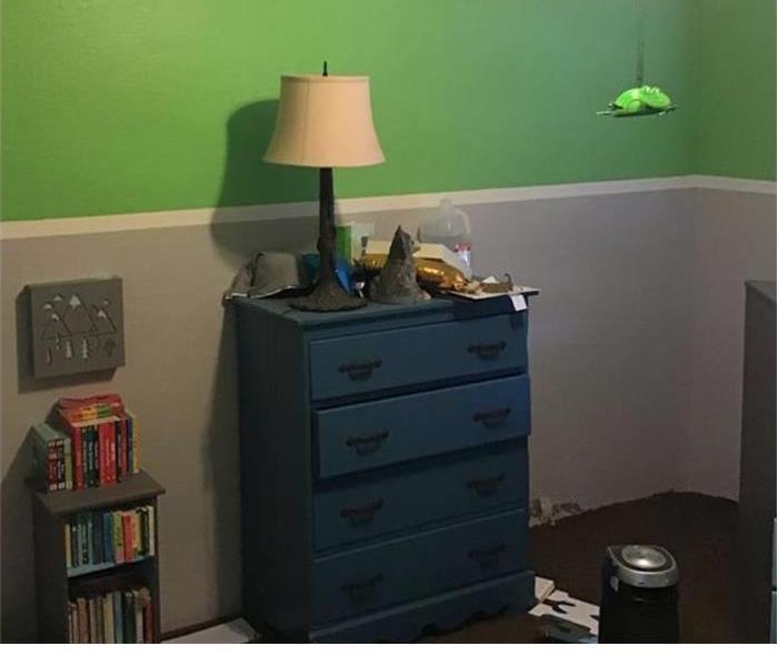 green and white room with a blue furniture with a lamp