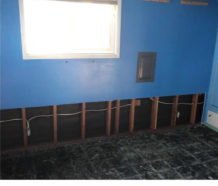 	empty room with blue walls with exposed framing in the bottom of the walls