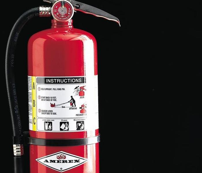 A red fire extinguisher with a black background